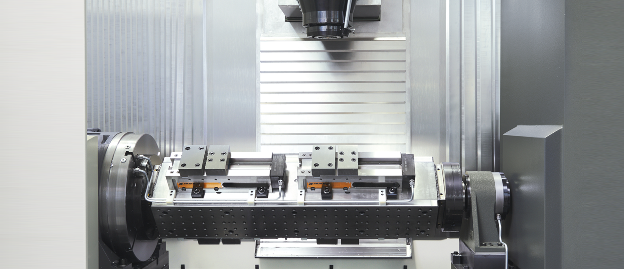 On the swivelling bridge several workpieces can be clamped in parallel and each machined on three sides